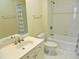 Clean and bright bathroom featuring a bathtub with shower, sink, toilet, and white tiled floors at 2801 Glenwood Gardens Ln # 106, Raleigh, NC 27608