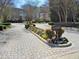 Well-maintained community entrance with manicured flowerbeds and brick-paved driveway at 2801 Glenwood Gardens Ln # 106, Raleigh, NC 27608