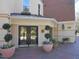 Inviting entryway with double glass doors, potted plants, and a well-maintained brick pathway at 2801 Glenwood Gardens Ln # 106, Raleigh, NC 27608