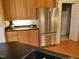 Modern kitchen featuring stainless steel refrigerator, wood cabinets, and black countertops at 2801 Glenwood Gardens Ln # 106, Raleigh, NC 27608