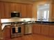 Stylish kitchen with stainless steel appliances, wooden cabinets, and a connecting view to the living room at 2801 Glenwood Gardens Ln # 106, Raleigh, NC 27608