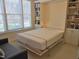 Murphy bed is shown pulled out in a versatile room with ample bookshelf storage and seating at 2801 Glenwood Gardens Ln # 106, Raleigh, NC 27608