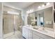 Bathroom featuring double sinks, a glass-enclosed shower, and a large mirror at 296 Providence Creek Dr, Fuquay Varina, NC 27526