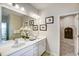Clean bathroom with double sinks, white cabinets, mirror, and access to the walk-in closet at 296 Providence Creek Dr, Fuquay Varina, NC 27526