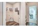 A well-lit hallway featuring hardwood floors leads to an office space, with shelving and decorations at 296 Providence Creek Dr, Fuquay Varina, NC 27526