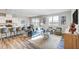 Open living room features hardwood floors, a blue sofa, a decorative rug, and natural light at 296 Providence Creek Dr, Fuquay Varina, NC 27526