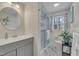 Bright bathroom features a modern vanity with an oval mirror and walk-in glass shower at 3022 Dixon Rd, Durham, NC 27707