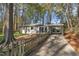 Home exterior view featuring a carport and inviting porch, nestled amidst a wooded area and a well-manicured lawn at 3022 Dixon Rd, Durham, NC 27707