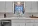 Bright kitchen sink with stainless steel faucet and view to window with natural light at 3022 Dixon Rd, Durham, NC 27707