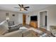 Cozy living room featuring stylish decor, a comfortable sofa, ceiling fan, and modern entertainment center with ample light at 3022 Dixon Rd, Durham, NC 27707