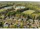 An aerial view shows a neighborhood with mature trees near a school and athletic fields at 317 Flatrock Ln, Holly Springs, NC 27540