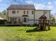 Large backyard with deck, playhouse, swing set, and fenced-in area offers space for Gathering activities at 317 Flatrock Ln, Holly Springs, NC 27540