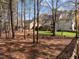 Wooded backyard with grassy area and playset provides both privacy and space for Gathering activities at 317 Flatrock Ln, Holly Springs, NC 27540
