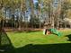 Backyard featuring lush green grass and a wooden playset with a slide, perfect for outdoor fun at 317 Flatrock Ln, Holly Springs, NC 27540