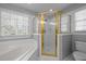 Bathroom featuring a corner tub, shower with gold trim and a bright window at 317 Flatrock Ln, Holly Springs, NC 27540
