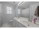 Bright bathroom featuring a double sink vanity, large mirror, and natural light from the window at 317 Flatrock Ln, Holly Springs, NC 27540