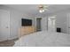 Spacious bedroom featuring a ceiling fan, dresser with TV, and view into the bathroom at 317 Flatrock Ln, Holly Springs, NC 27540