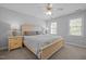Comfortable bedroom with a large bed, ceiling fan and two windows providing natural light at 317 Flatrock Ln, Holly Springs, NC 27540