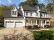 Beautiful white home with a spacious three car garage, well-manicured lawn, and welcoming front porch at 317 Flatrock Ln, Holly Springs, NC 27540