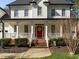 Inviting entrance with a striking red door, brick steps, and a well-maintained front garden at 317 Flatrock Ln, Holly Springs, NC 27540