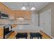 Well-lit kitchen with a central island and white countertops, oak cabinets, and stainless steel appliances at 317 Flatrock Ln, Holly Springs, NC 27540