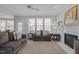 Comfortable living room with a fireplace, ample seating, and a view of the backyard through large windows at 317 Flatrock Ln, Holly Springs, NC 27540