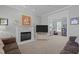 Light-filled living room with marble fireplace and adjacent sitting area with bright window at 317 Flatrock Ln, Holly Springs, NC 27540