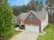 Aerial view of brick and siding home with well-maintained lawn and paved driveway and garage at 3213 Kirby St, Durham, NC 27713