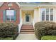 Inviting front porch with brick steps, white railings, and manicured bushes on either side at 3213 Kirby St, Durham, NC 27713