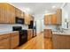 Traditional kitchen with wood cabinets, stainless steel appliances, tile backsplash, and hardwood floors at 3213 Kirby St, Durham, NC 27713