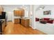 Open kitchen view showcasing wood cabinets, black appliances, hardwood floors, and a clear view into the living room at 3213 Kirby St, Durham, NC 27713
