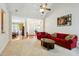 Bright living room featuring plush red sofas, a neutral carpet, and an open floor plan with views to other rooms at 3213 Kirby St, Durham, NC 27713