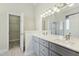 Main bathroom featuring dual sinks, quartz countertops, grey cabinets, and a glass shower stall at 3213 Kirby St, Durham, NC 27713