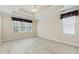 A bright main bedroom with a tray ceiling, ceiling fan, and light wood flooring at 3213 Kirby St, Durham, NC 27713