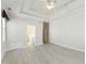 A bright main bedroom with a tray ceiling, ceiling fan, light wood flooring, and a bathroom at 3213 Kirby St, Durham, NC 27713