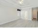 A bright main bedroom with a tray ceiling, ceiling fan, light wood flooring, and access to the bathroom at 3213 Kirby St, Durham, NC 27713