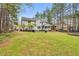 Expansive backyard featuring a sunroom, lush lawn, and mature trees, perfect for outdoor living and entertaining at 384 Rocky Run Ln, Lillington, NC 27546