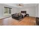 A bedroom is shown with a hardwood floor, neutral walls, and a sitting area by a window at 384 Rocky Run Ln, Lillington, NC 27546
