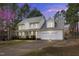 Charming two-story home with a two-car garage and well-manicured landscaping at dusk at 384 Rocky Run Ln, Lillington, NC 27546