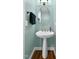 Powder room featuring a pedestal sink, oval mirror, and updated vanity lighting at 384 Rocky Run Ln, Lillington, NC 27546