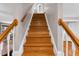 Staircase features hardwood steps, white risers, and a stained handrail at 384 Rocky Run Ln, Lillington, NC 27546