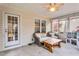 This sunroom features seating, a wooden table, and a play kitchen for Gathering enjoyment at 384 Rocky Run Ln, Lillington, NC 27546