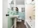 Bathroom with aqua tile, pedestal sink, and shower/tub with built-in shelves for toiletries at 416 Avery St, Garner, NC 27529