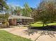 A charming brick home showcasing a spacious driveway, inviting front porch, and lush green lawn at 416 Avery St, Garner, NC 27529