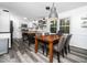 Eat-in kitchen with modern wood table and chairs, white cabinetry, and stylish wood-look flooring at 416 Avery St, Garner, NC 27529