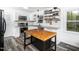 Modern kitchen with white cabinets, stainless steel appliances, butcher block island, and stylish backsplash at 416 Avery St, Garner, NC 27529