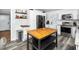 Modern kitchen with stainless steel appliances, white cabinets, butcher block island, and contemporary flooring at 416 Avery St, Garner, NC 27529