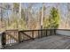 View of a stained wood deck overlooking a wooded backyard in a cozy home at 4229 American Dr # F, Durham, NC 27705
