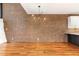 Spacious living room featuring exposed brick wall, hardwood floors, and pendant lighting at 4229 American Dr # F, Durham, NC 27705