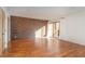 Sunlit living room with hardwood floors and exposed brick accent wall at 4229 American Dr # F, Durham, NC 27705